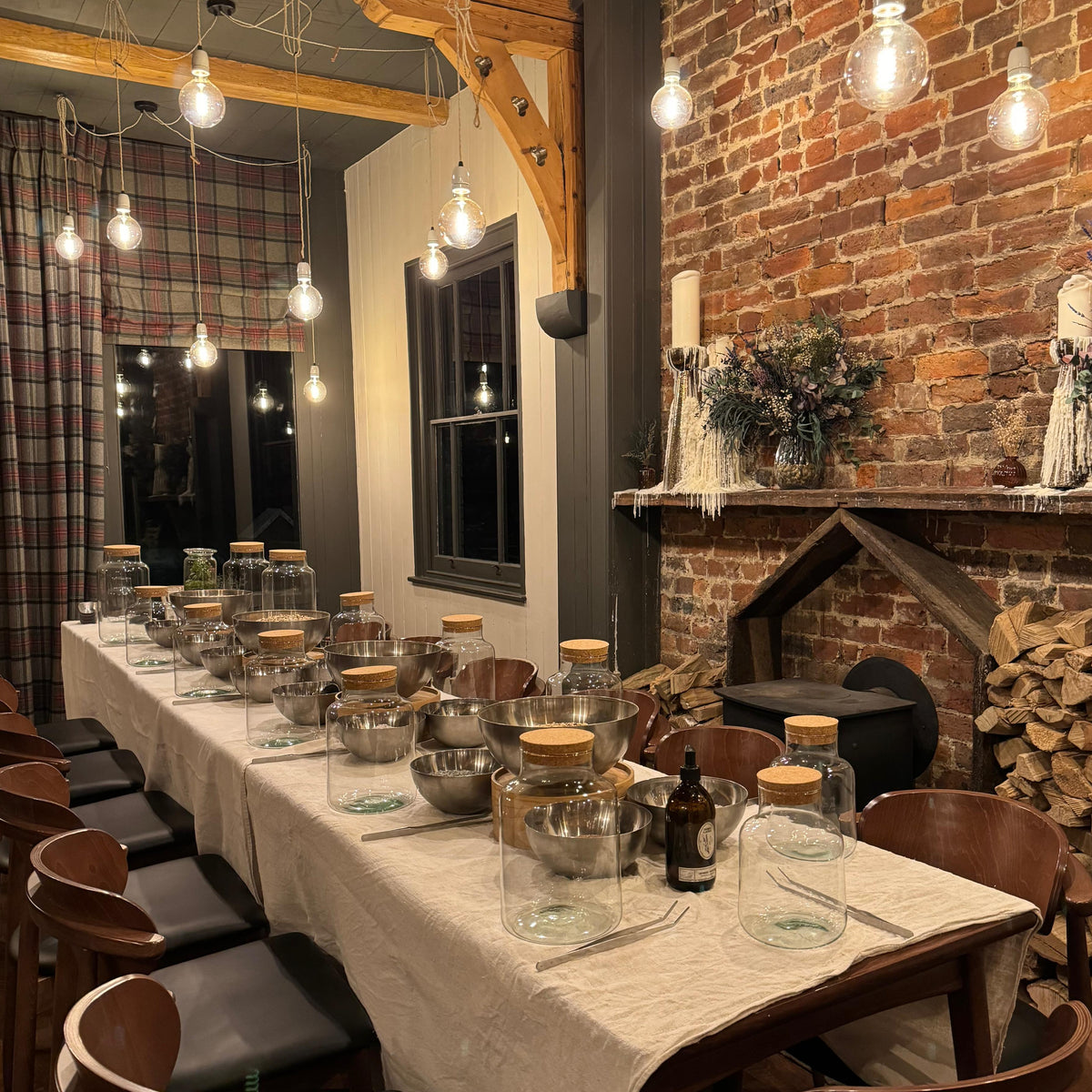 The interior of Tallow, featuring a long empty table set for a terrarium workshop. Vessels of assorted sizes line the table, with materials down the center. 